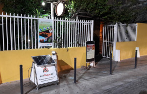 Entrada do restaurante a noite, iluminado pela energia renovável.